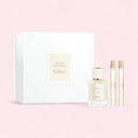 Chloe Atelier Des Fleurs perfume set of 1 x Cedrus Eau De Parfum 50ml bottle, 1 x Magnolia Alba Eau de Parfum pen spray 10ml and 1 x Ylang Cananga Eau de Parfum pen spray 10 ml with a white box on a pink background