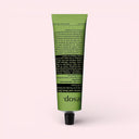 Green tube of Aesop Geranium Leaf Body Balm 100ml on a light pink background