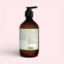 back view of Brown Aesop Geranium Leaf Body Balm 500ml bottle with pump on a light pink background