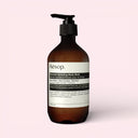 Aesop Resolute Hydrating Body Balm 500ml bottle on a light pink background