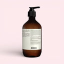 back view ofAesop Resurrection Aromatique Hand Balm 500ml Brown bottle with pump on a light pink background