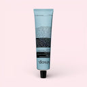 Blue tube ofAesop Reverence Aromatique Hand Balm 75ml on a light pink background
