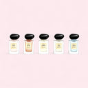 Five armani prive perfume bottles with black caps on a pink background