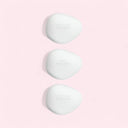 Three white irregular oval shaped hand soap products from the Armani Privé Les Eaux Hand Soaps Discovery Trio Set with 'Pivoine Suzhou', 'THE YULONG' and 'Vétiver d’Hiver' branding on the hand soup bars on a pink background | BEAUTE KNOWS AUSTRALIA