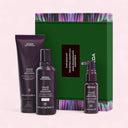 Aveda hair care products including shampoo, conditioner, and serum with a green box in the background.