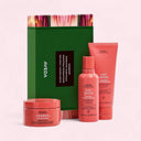 Aveda hair care product set including shampoo, conditioner, and mask on a pink background