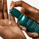 Hand holding a bottle Aveda botanical repair strengthening overnight serum bottle | BEAUTE KNOWS AUSTRALIA