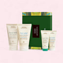 Aveda Hand Relief™ & Foot Relief™ Essentials Set products with a green box on a pink background