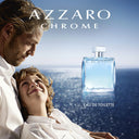 Azzaro Chrome advertisement with a man and child by the ocean and a blue Azzaro perfume bottle.