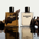 Two Burberry Hero perfume bottles on a reflective surface with a neutral background