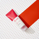 BEAUTE KNOWS Red and white Beauty of Majesty BOM AC Red Free Cream 50ml tube on a polka dot and solid red background