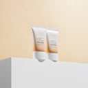 Two tubes ofBeauty of Majesty BOM Foundation-Free Tone Cover Sun Cream SPF50+PA++++ 50g on a beige and white background