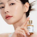 Woman holding a Beauty of Majesty BOM Peptide Power Ampoule 30ml bottle against a white background
