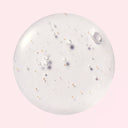 Close-up of Beauty of Majesty BOM Peptide Power Toner swatch with bubbles and gold on a pink background