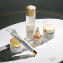 Set of Beauty of Majesty BOM Peptide products including power cream, power eye cream, power toner, power ampoule and sleeping mask on a white surface with a clock in the background.