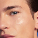 Close-up of a person's face with a focus on the skin texture and highlighter application.