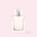 Clear perfume bottle with silver cap on a light pink background