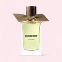Burberry Oud Storm perfume bottle with a brown ribbon on a light pink background