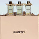 Three Burberry perfume bottles with a beige box featuring the Burberry logo.