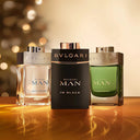 Three Bvlgari men's Miniature fragrances on a reflective surface with a blurred background