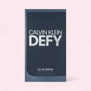 Calvin Klein Defy perfume packaging on a light pink background
