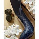 Carolina Herrera Good Girl Supreme Eau De Parfum Black and blue glittery high heel shoe shaped perfume bottle on a gold surface with white flowers and berry