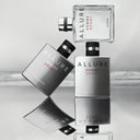 Allure Homme Sport perfume bottles on a reflective surface with a light gray background