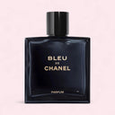 Bleu de Chanel parfum bottle labeled with gold fonts on a light pink background