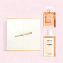 Chanel Coco Mademoiselle Eau de Parfum 100ml perfume bottle and Coco Mademoiselle Body Oil 200ml bottle and Coco Mademoiselle Gift Set Packaging on a pink background