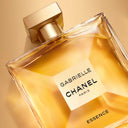Chanel Gabrielle Essence Eau de Parfum 100ml perfume bottle with gold cap on a golden orange background