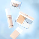 Chanel skincare products including le blanc cream, le blanc serum, liquid foundation and compact on a light blue background