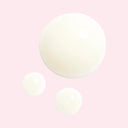 Pastel pink background with texture view of 3 drops of Chanel N°1 De Chanel Revitalizing Eye Serum 