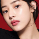 Close-up of a asian women's clear, illuminating, poreless face with a red background