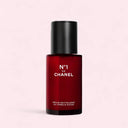Red bottle of Chanel N°1 De Chanel Revitalizing Serum 30ml with black cap on a light pink background
