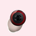 birdeye view of Chanel N°1 De Chanel Revitalizing Serum 50ml bottle with red and black design on a light pink background