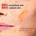 Close-up of a person's face with a droplet of Clarins Double Serum  product, showing text about skin smoothing and radiance.