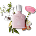 BEAUTE KNOWS Pale pink Creed Spring Flower Eau De Parfum 75ml perfume bottle surrounded by flowers and fruit on a white background