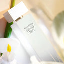 Close up of Elizabeth Arden White Tea Eau De Toilette 100ml perfume bottle with a flower in the background