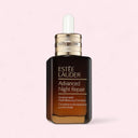 Estée Lauder Advanced Night Repair serum bottle on a light pink background
