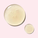 BEAUTE KNOWS Two droplets of yellow Estée Lauder Advanced Night Repair Synchronized Multi-Recovery Complex liquid on a pink background