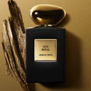 Black Armani Prive Oud Royal perfume bottle with gold cap on a beige background