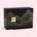 Black gift box with white dot pattern and Armani Prive logo on a pink background