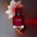 BEAUTE KNOWS Red Givenchy L'interdit Rouge Eau De Parfum 80ml perfume bottle with a white flower on a gradient background