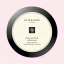 Jo Malone English Pear & Freesia body crème container on a light pink background