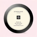 Jo Malone Peony & Blush Suede 175ml body crème container on a light pink background