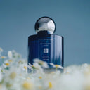 Jo Malone perfume bottle with flowers on a blue background