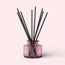 BEAUTE KNOWS Jo Malone London Garnet Glass Diffuser Pink diffuser glass with black sticks on a light pink background