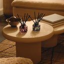 BEAUTE KNOWS Two Jo Malone London diffuser glass bottles on a round table with a blurred background