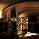 BEAUTE KNOWS Kilian Angels' Share All-Over Body Spray 150ml and Kilian Angel's Share Eau De Parfum perfume bottle on a wooden barrel surface with a blurred background