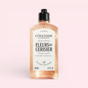 L’occitane Cherry Blossom Fleurs de cerisier perfumed Shower Gel 250ml bottle on a light pink background